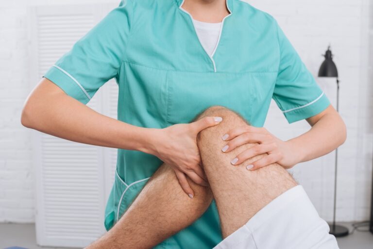 cropped shot of massage therapist doing leg massage to patient in clinic